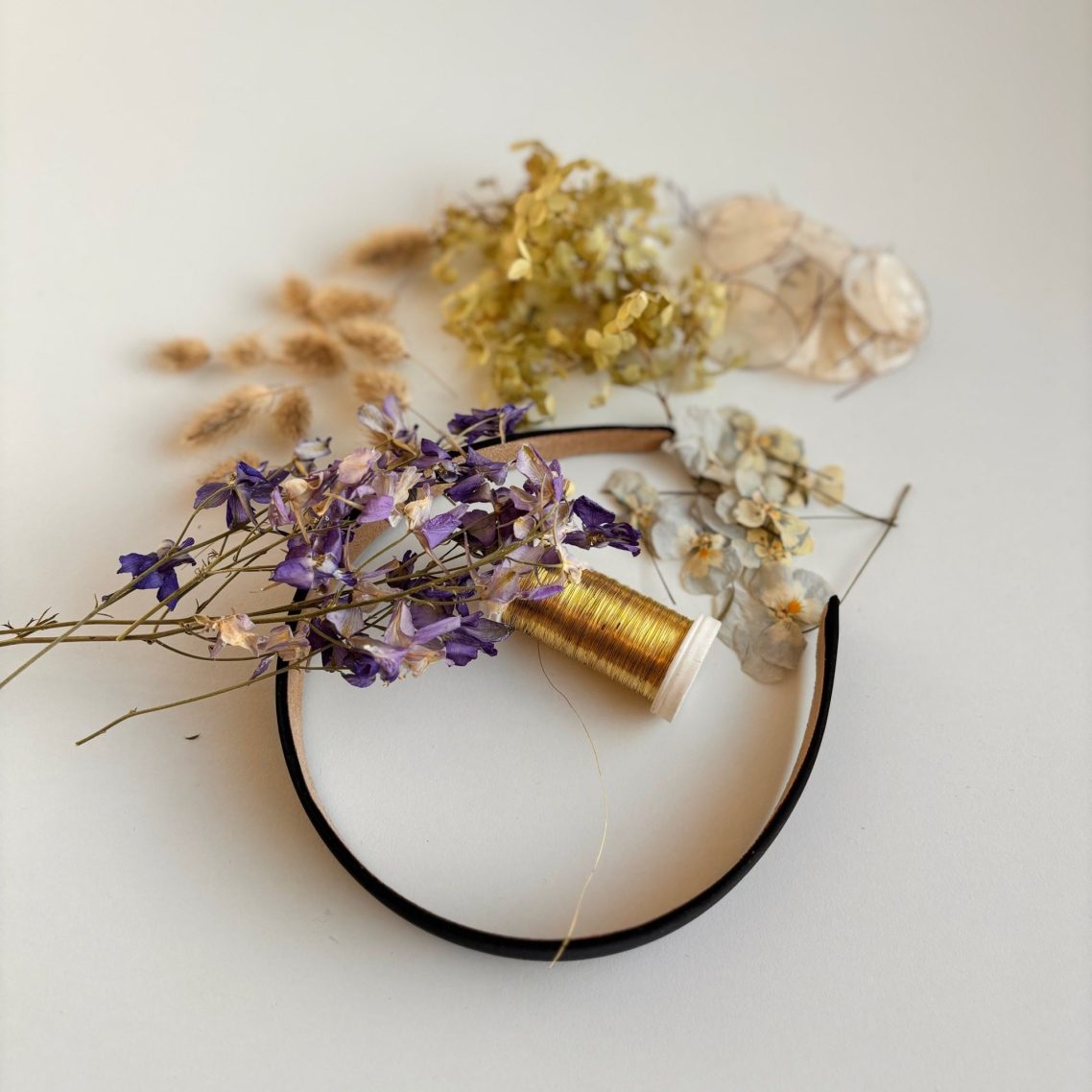 Schwarzer Haarreif mit getrockneten blauen und beige Blumen. Vorbereitung für Kreativ Workshop München.