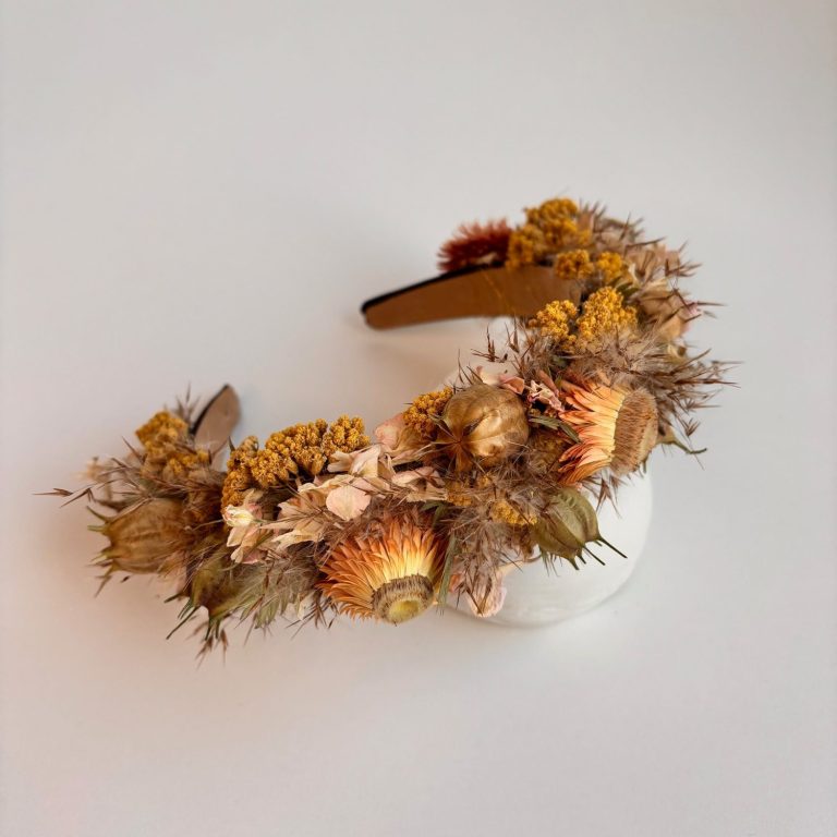 Blumenhaarreifen aus getrockneten Blumen und Gräsern in warmen Farbtönen.